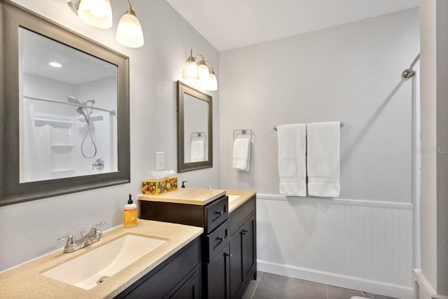 bathroom with tile patterned floors, vanity, and walk in shower