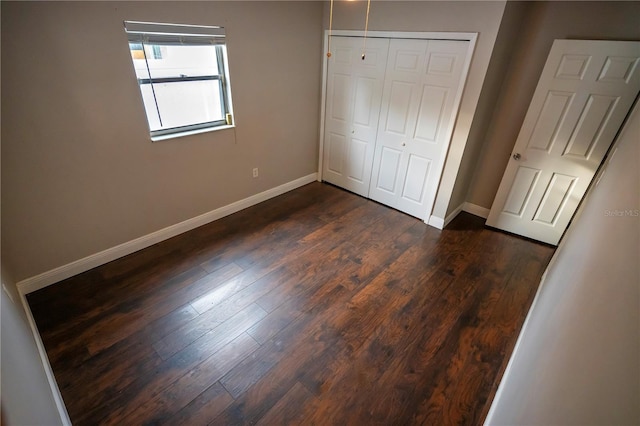 unfurnished bedroom with a closet and dark hardwood / wood-style flooring