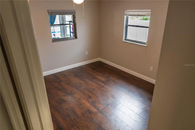 unfurnished room with dark hardwood / wood-style flooring and plenty of natural light