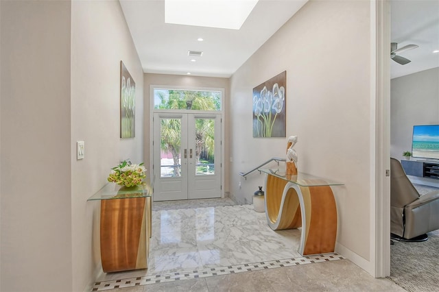 entrance foyer featuring a skylight, ceiling fan, and french doors