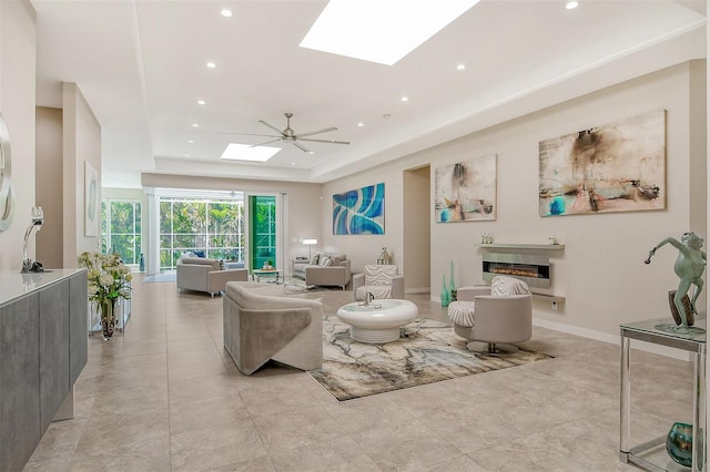 living room featuring a tray ceiling and ceiling fan