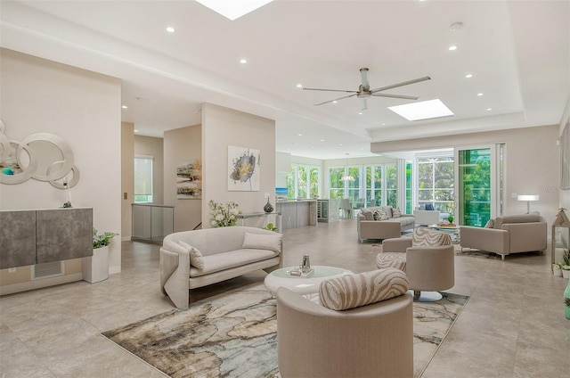 living room featuring ceiling fan and a skylight