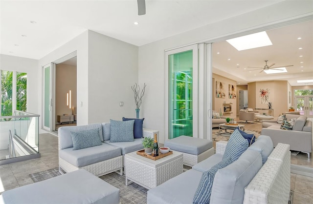 living room featuring ceiling fan and a skylight