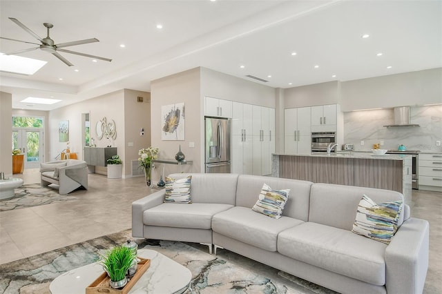 living room featuring a skylight and ceiling fan