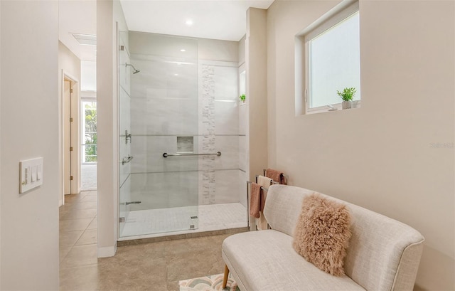 bathroom with tile patterned flooring, a wealth of natural light, and a shower with shower door