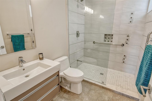 bathroom with vanity, toilet, and tiled shower