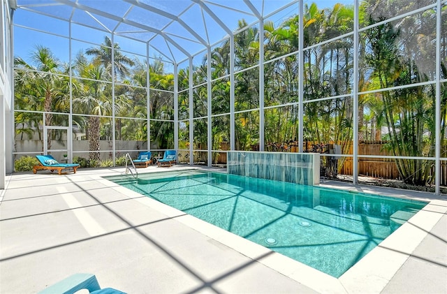 view of swimming pool featuring glass enclosure and a patio