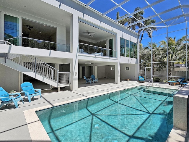 view of swimming pool with glass enclosure, ceiling fan, and a patio area