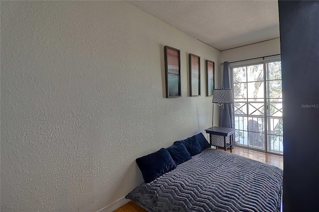 bedroom with hardwood / wood-style floors and a textured ceiling