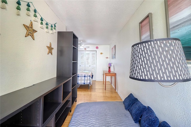 hallway with hardwood / wood-style floors and a textured ceiling