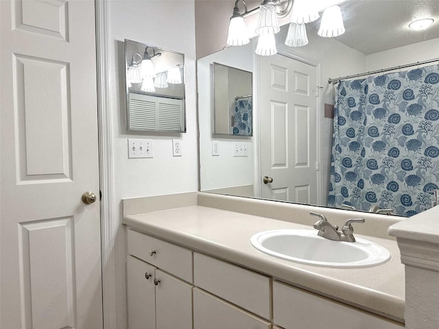 bathroom featuring vanity, curtained shower, and a textured ceiling