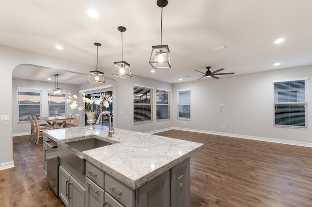 kitchen with a kitchen island with sink, open floor plan, decorative light fixtures, and dishwasher