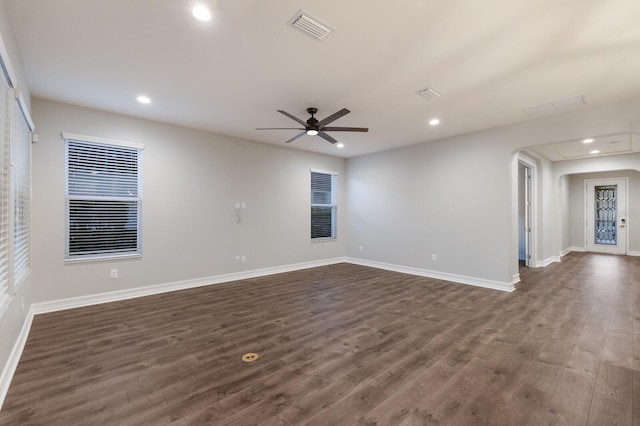 unfurnished room featuring baseboards, visible vents, and dark wood-type flooring