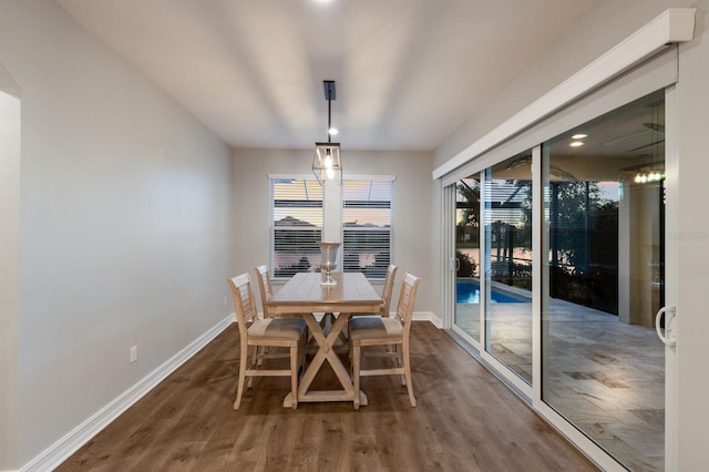 dining area with dark wood-type flooring, a wealth of natural light, and baseboards