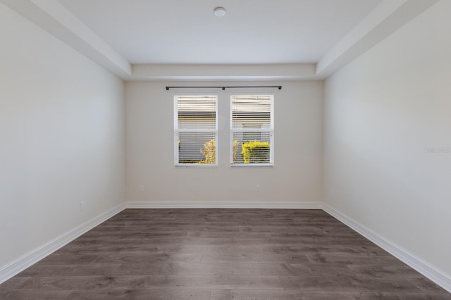 empty room with baseboards and dark wood finished floors