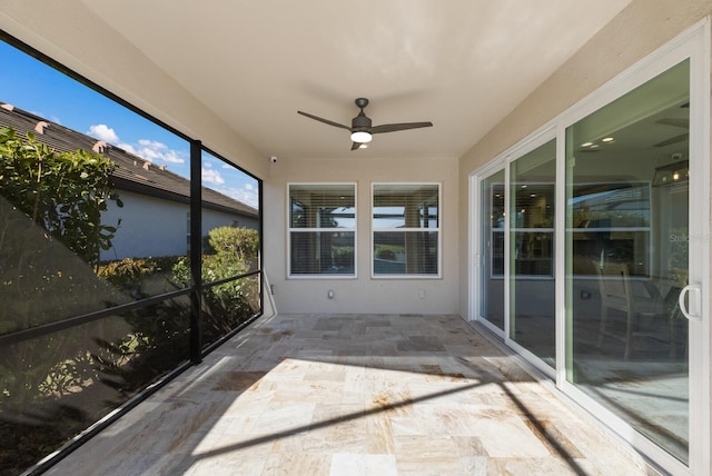 unfurnished sunroom featuring a ceiling fan