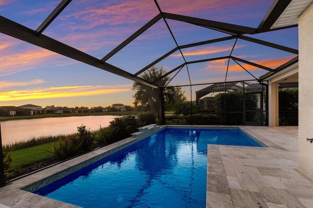 pool at dusk with a lanai, a water view, an outdoor pool, and a patio