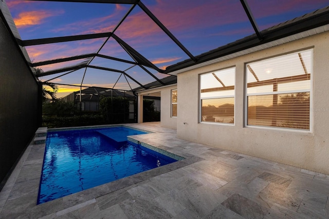 pool with glass enclosure and a patio