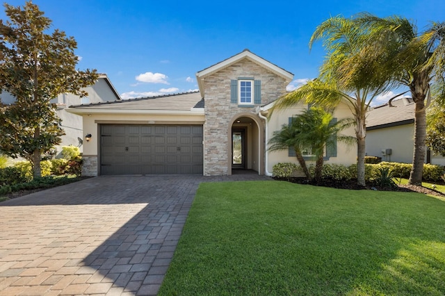 view of front of property featuring decorative driveway, stucco siding, an attached garage, stone siding, and a front lawn