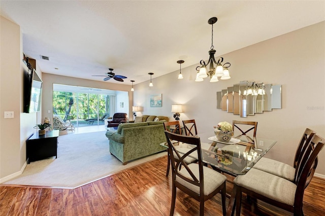 dining area featuring ceiling fan with notable chandelier and hardwood / wood-style flooring