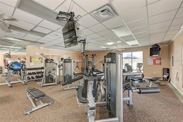 workout area with carpet flooring, a paneled ceiling, and ornamental molding