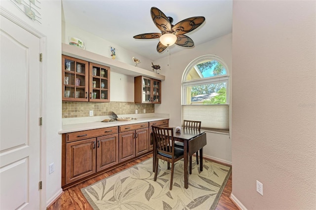 kitchen featuring hardwood / wood-style floors, backsplash, and ceiling fan