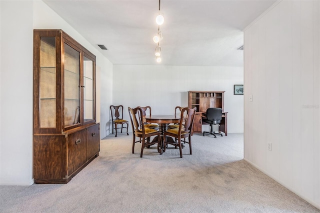 dining space featuring light carpet