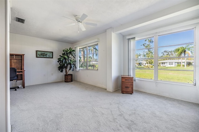 unfurnished room with ceiling fan, a healthy amount of sunlight, and light carpet