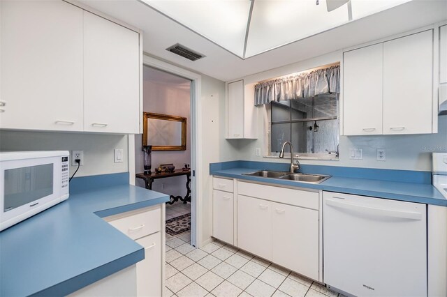 kitchen featuring white cabinets, light tile patterned floors, white appliances, and sink