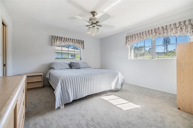 carpeted bedroom with multiple windows and ceiling fan