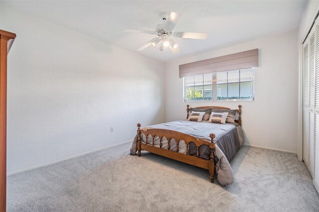 bedroom featuring light carpet, a closet, and ceiling fan