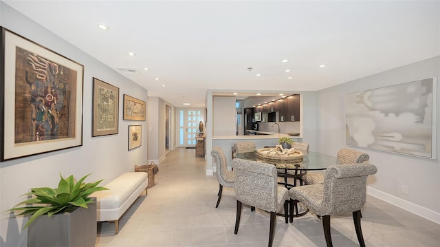 dining space featuring light tile patterned floors and sink