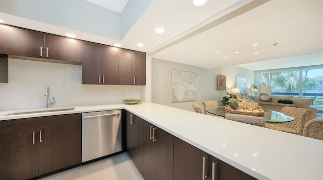 kitchen featuring backsplash, stainless steel dishwasher, dark brown cabinets, sink, and light tile patterned floors