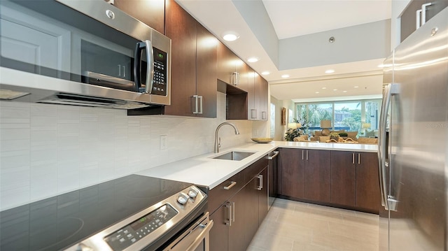 kitchen with backsplash, sink, dark brown cabinets, light tile patterned flooring, and stainless steel appliances