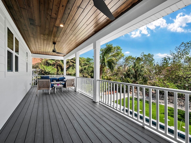 wooden terrace featuring ceiling fan, a yard, and an outdoor hangout area