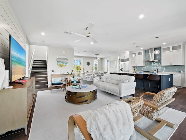 living room with ceiling fan and dark wood-type flooring