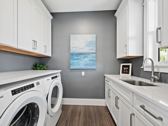 clothes washing area featuring separate washer and dryer, dark wood-type flooring, cabinets, and sink