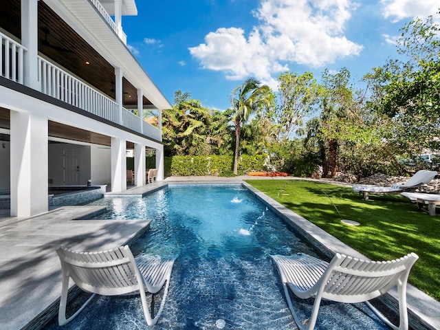 view of swimming pool featuring a lawn, pool water feature, and a patio