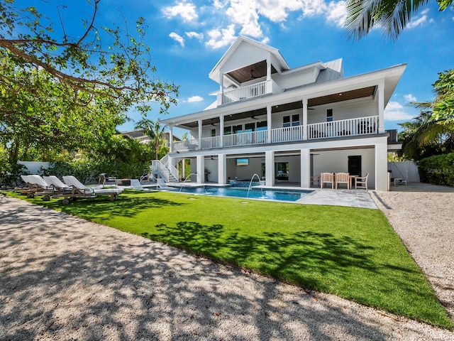 rear view of house featuring a patio area, a balcony, and a yard