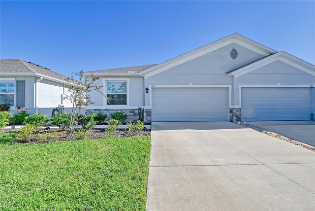 ranch-style home with a garage and a front lawn