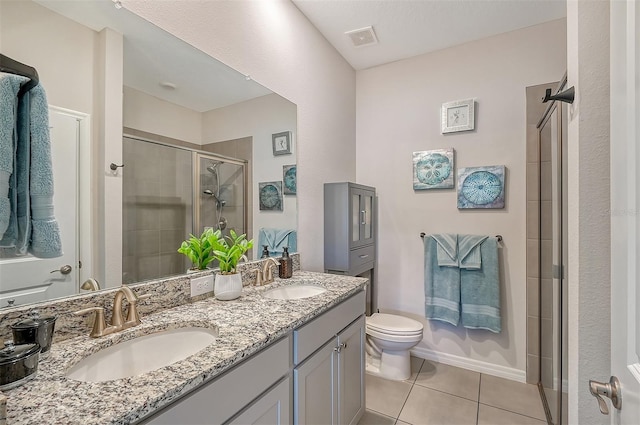 bathroom with tile patterned floors, vanity, an enclosed shower, and toilet