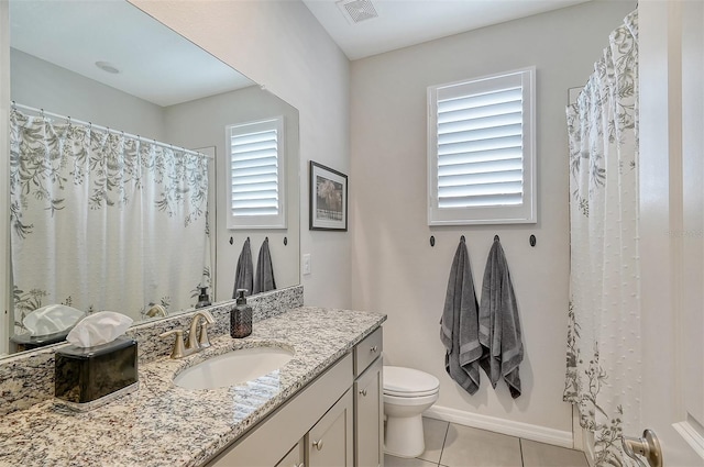 bathroom featuring a wealth of natural light, tile patterned flooring, vanity, and toilet