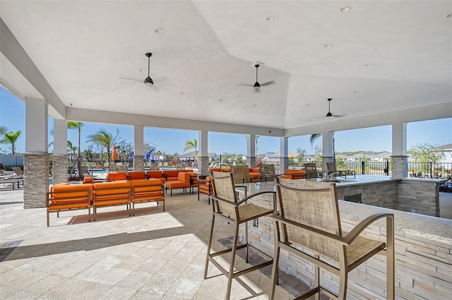 view of patio featuring ceiling fan, exterior bar, and an outdoor hangout area