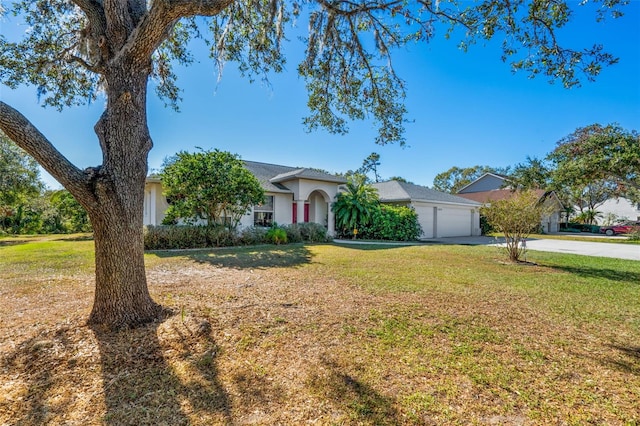 ranch-style house featuring a garage and a front lawn