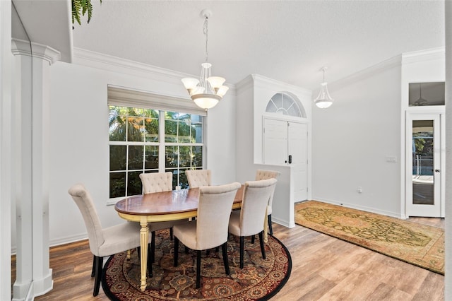 dining area with a chandelier, a textured ceiling, hardwood / wood-style flooring, and crown molding