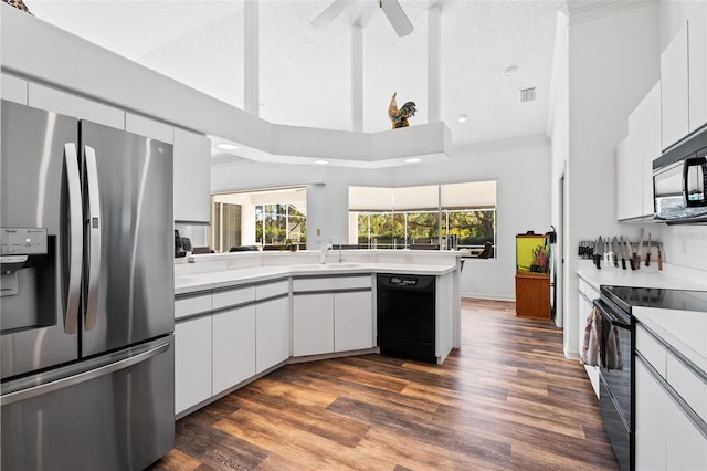 kitchen with sink, black appliances, white cabinets, a high ceiling, and dark hardwood / wood-style floors