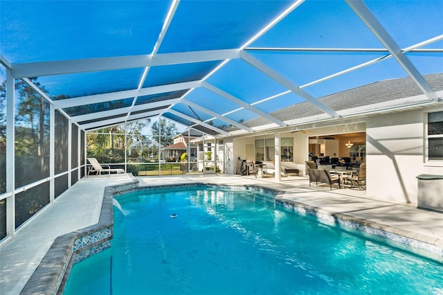 view of pool with pool water feature, glass enclosure, ceiling fan, and a patio