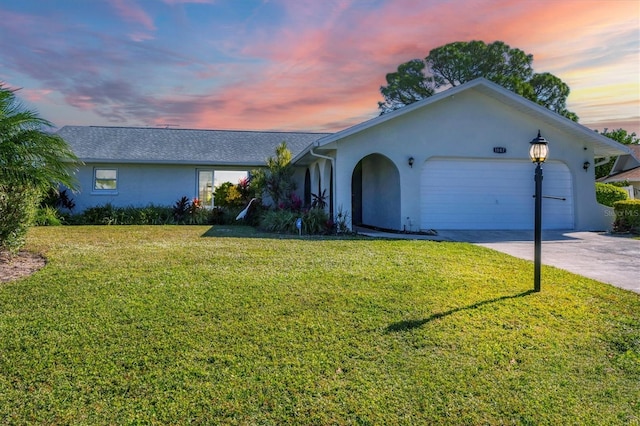 single story home featuring a yard and a garage