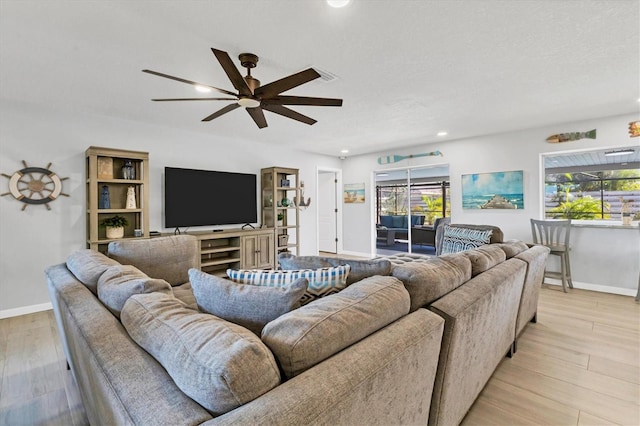 living room with light hardwood / wood-style floors and ceiling fan