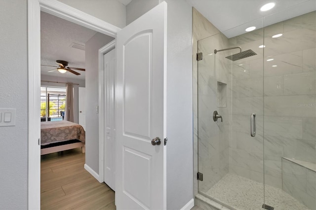 bathroom with ceiling fan, wood-type flooring, and walk in shower